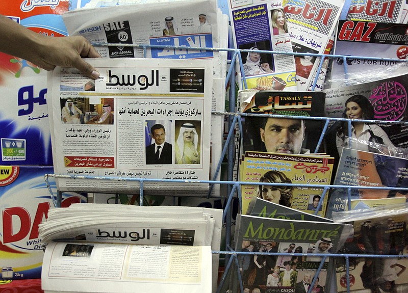 
              File - In this Tuesday, April 5, 2011, file photo, a man picks up a copy of Al Wasat newspaper at a newsstand in Hamad Town, Bahrain. Bahraini authorities have ordered the independent newspaper to stop publishing online Monday and say a city hall was set ablaze during clashes between opposition protesters and police. The suspension of Al-Wasat’s online operations followed a spike in anti-government protests led by the country’s Shiite majority that began Saturday.  (AP Photo/Hasan Jamali, File)
            