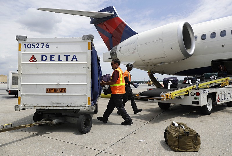 
              FILE - In this July 12, 2016, file photo, workers unload baggage from a Delta Air Lines flight at Baltimore-Washington International Thurgood Marshall Airport in Linthicum, Md. On Tuesday, Jan. 17, 2017, the federal Department of Transportation reported that U.S. airlines are improving on-time arrivals and canceling fewer flights. Hawaiian Airlines and Delta Air Lines posted the best rates for on-time arrivals. (AP Photo/Patrick Semansky, File)
            