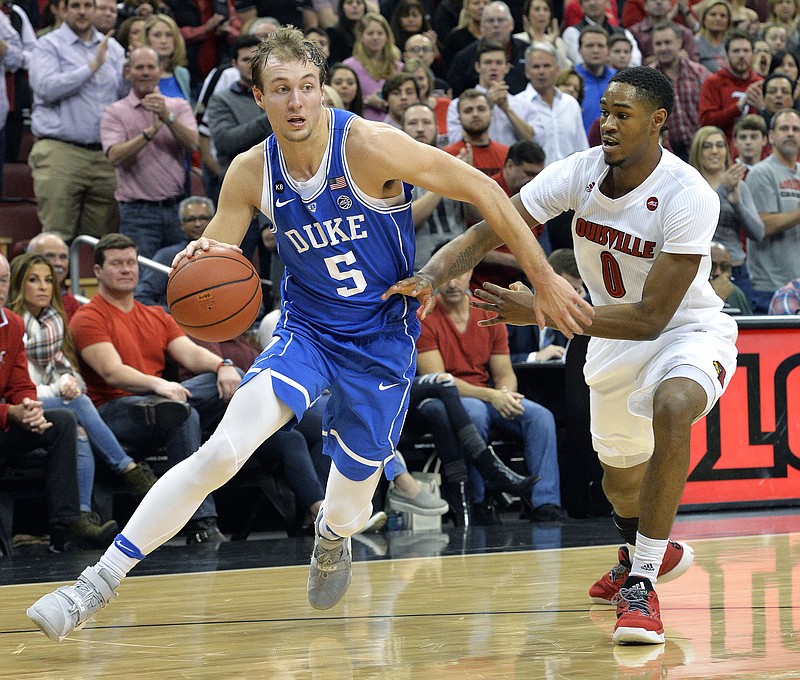 Duke's Luke Kennard (5) attempts to drive around the defense of Louisville's V.J. King (0) during the first half of an NCAA college basketball game, Saturday, Jan. 14, 2017, in Louisville, Ky. (AP Photo/Timothy D. Easley)