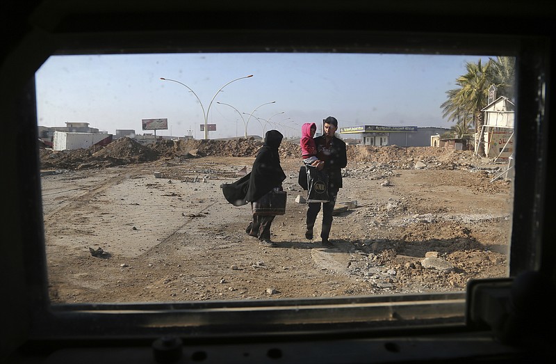 
              In this picture taken through the windshield of Iraq's special forces armored vehicle, civilians leave their neighborhoods during fighting between Iraqi security forces and Islamic State militants in the eastern Mosul and the Tigris river which divides the city. (AP Photo/ Khalid Mohammed)
            