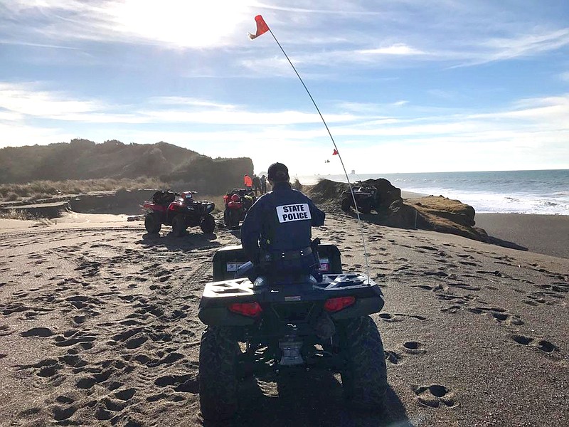 
              In this photo provided by the Oregon State Police taken Sunday, Jan. 15, 2017, OSP troopers on all-terrain vehicles search a beach about two miles north of Cape Blanco, Oregon, where a father and his young son were swept out to sea Sunday as they walked near the surf. (Oregon State Police via AP)
            
