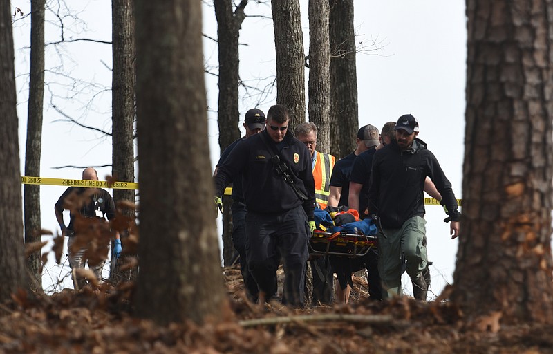 Emergency personnel carry a body to an ambulance on Forest Park Road Wednesday, January 18, 2017 after a worker with Big Woody's Tree Service fell 150 feet from a Signal Mountain bluff.
