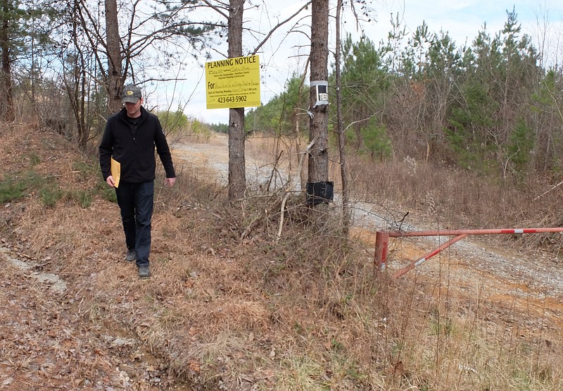 Justin Whaley walks away from the planning notice sign proposing a special permit outdoor shooting range on Bakewell Mountain in north Hamilton County. The 184-acres are located on Retro Hughes Road.