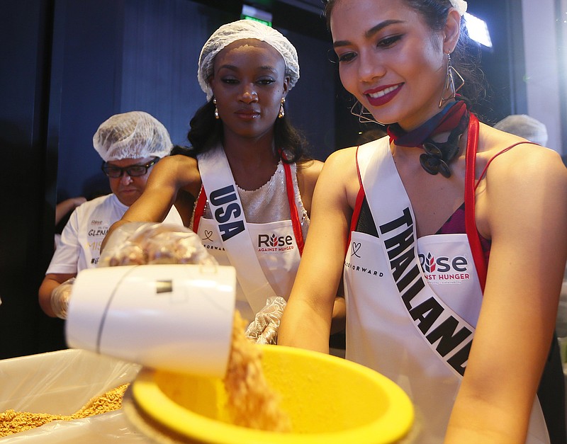 
              Miss Universe contestants Deshauna Barber of the United States and Chalita Suansane of Thailand help pack meals for distribution to the needy in suburban Pasay city southeast of Manila, Philippines Wednesday, Jan. 18, 2017. Eighty-six candidates from around the world are vying for the title to succeed Pia Wurtzbach from the Philippines. The competition takes place on Jan. 30. (AP Photo/Bullit Marquez)
            