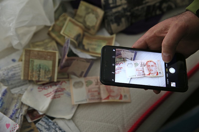 
              A member of the media uses his mobile phone to take pictures of belongings including banknotes of different currencies on a bed inside the flat where a suspect of New Year's Day nightclub attack was arrested during an overnight police raid, in Istanbul, Tuesday, Jan. 17, 2017. Turkish police said they captured the gunman who carried out the deadly New Year's nightclub attack in Istanbul, with officials saying Tuesday that he's an Uzbekistan national who trained in Afghanistan and confessed to the massacre.(AP Photo/Lefteris Pitarakis)
            