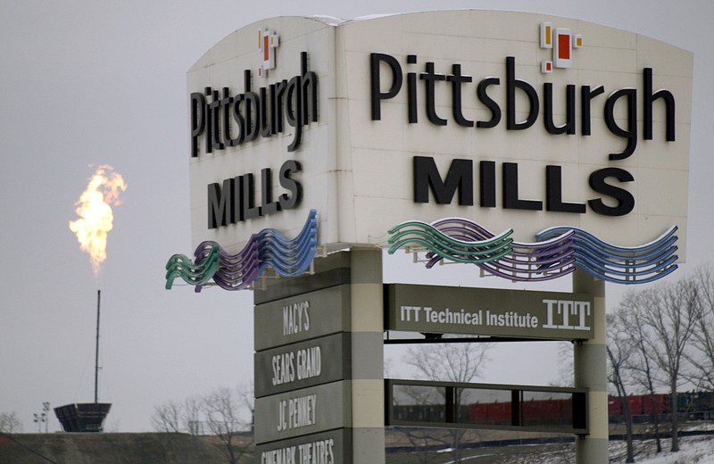 
              FILE - In this Jan. 11, 2011 file photo, the flare from the gas burn off from a Marcellus shale well is seen over the Pittsburgh Mills mall in Tarentum, Pa. The Pennsylvania mall that was foreclosed on after its owners failed to repay $143 million has been auctioned off for $100.  (AP Photo/Keith Srakocic, File)
            