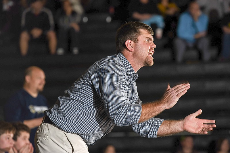 Soddy-Daisy coach Jim Higgins adds encouragement to his wrestler Hayden Maynor as he ties the match with Henley Headrick of Bradley Central Thursday night in Cleveland.
