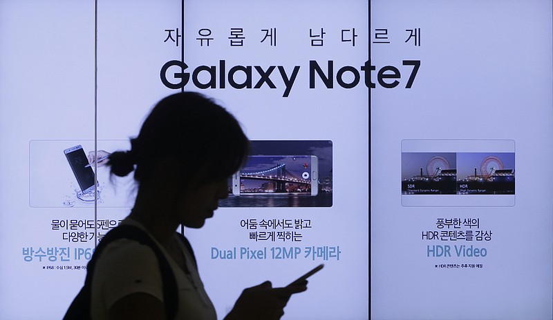 
              FILE - In this Sept. 2, 2016, file photo, a woman walks by an advertisement of Samsung Electronics' Galaxy Note 7 smartphone at the company's showroom in Seoul, South Korea. Samsung Electronics said Friday, Jan. 20, 2017 it will announce the reason why its Galaxy Note 7 smartphones overheated and caught fire on Jan. 23. (AP Photo/Ahn Young-joon, File)
            