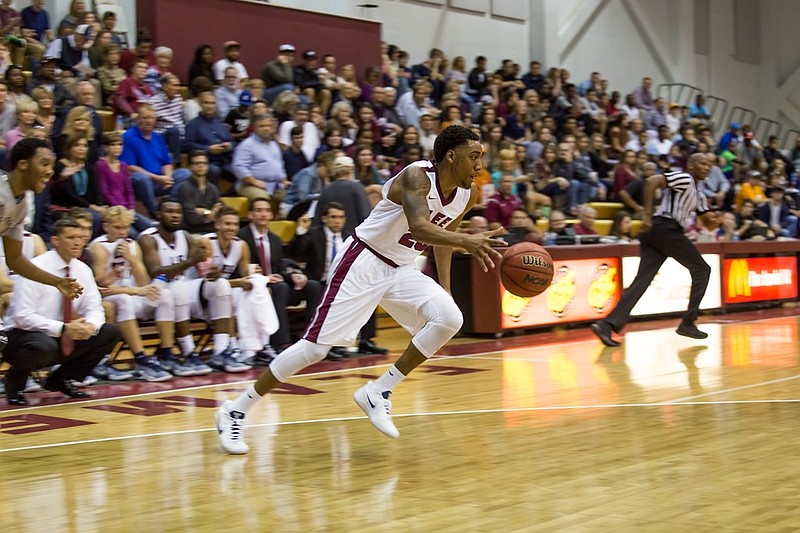 Jervon Johnson looks up court with the ball during a Lee University basketball game. 