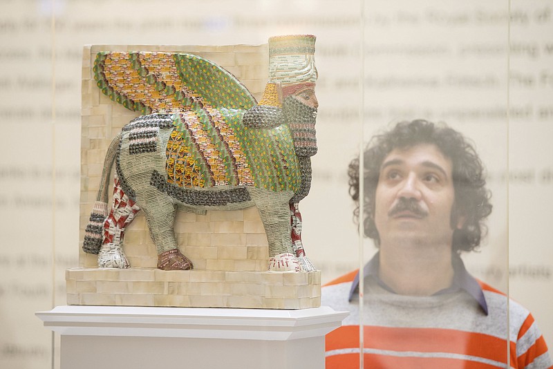 
              Artist Michael Rakowitz with a model of his artwork 'The Invisible Enemy Should Not Exist', on display at the National Gallery, London  Thursday Jan. 19, 2017., which has been shortlisted for the next Fourth Plinth commission in Trafalgar Square. A recreation of an ancient sculpture destroyed by the Islamic State group is among finalists for a place in London's Trafalgar Square. (Dominic Lipinski/PA via AP)
            