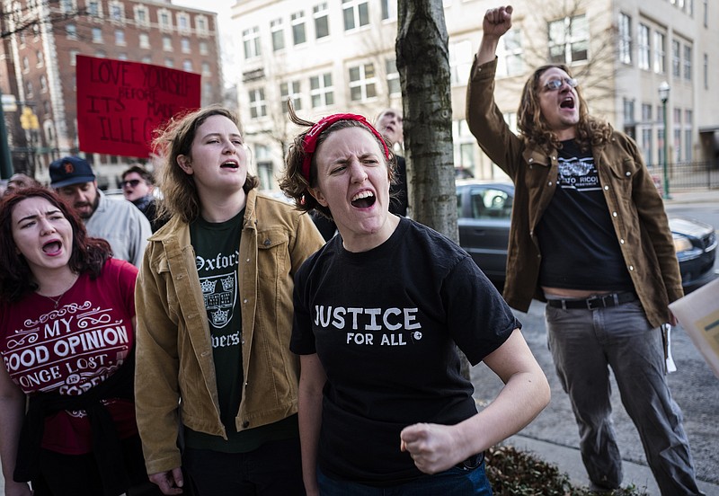 Emily Rowcliffe, Marianne Sanders, Kelly Ann Graff, and Nathan King, from left, chant during a protest outside of EPB headquarters on Martin Luther King, Jr., Boulevard directed towards Sen. Bob Corker's office on Friday, Jan. 20, 2017, in Chattanooga, Tenn. Demonstrators from Concerned Citizens for Justice gathered for a "Resist Trump Rally" to protest the inauguration of President Donald Trump and several of his cabinet nominations which Sen. Corker will oversee.