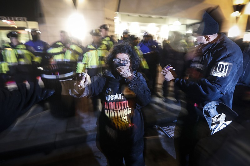 
              Protesters cover their faces after being pepper sprayed following a scuffle outside the National Press Club ahead of the presidential inauguration, Thursday, Jan. 19, 2017, in Washington. (AP Photo/John Minchillo)
            