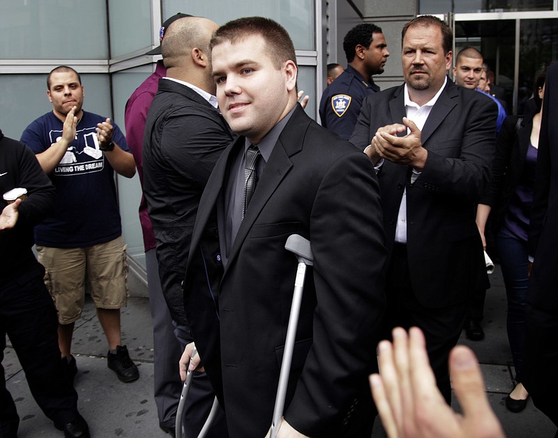 
              FILE - In this June 13, 2012, file photo, police officers and supporters clap as Officer Richard Haste, center, exits the courthouse after posting bail in New York. Haste pleaded not guilty to manslaughter charges in the shooting death of unarmed, black teenager Ramarley Graham. Haste was expected to offer his first public account of the slaying at his department disciplinary trial on Friday, Jan. 20, 2017. Haste initially faced a criminal manslaughter charge in the 2012 death of Graham, but the case was ultimately dismissed.  (AP Photo/Seth Wenig, File)
            