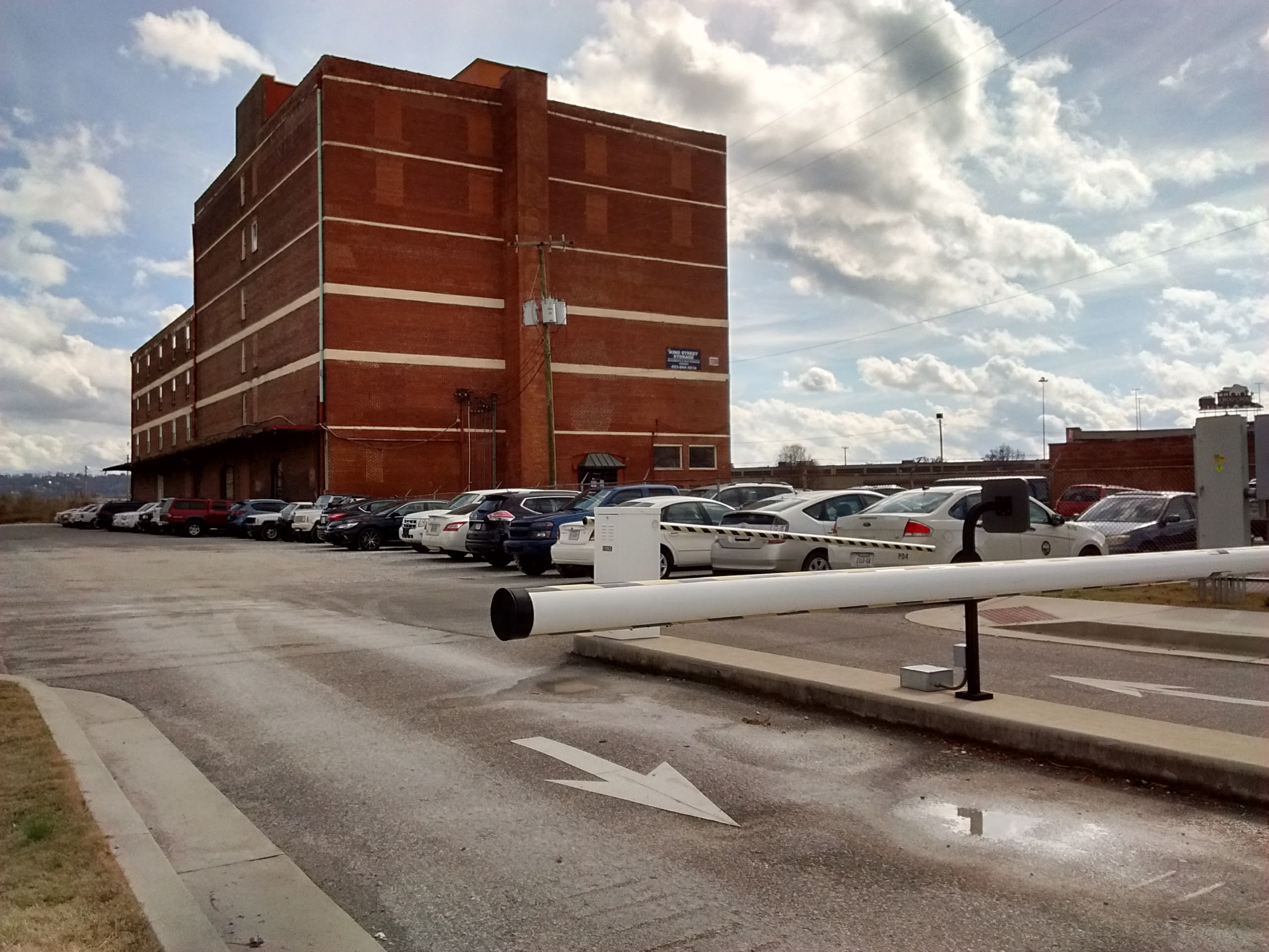 A gate controls access to a city-owned parking lot at 1200 King St.