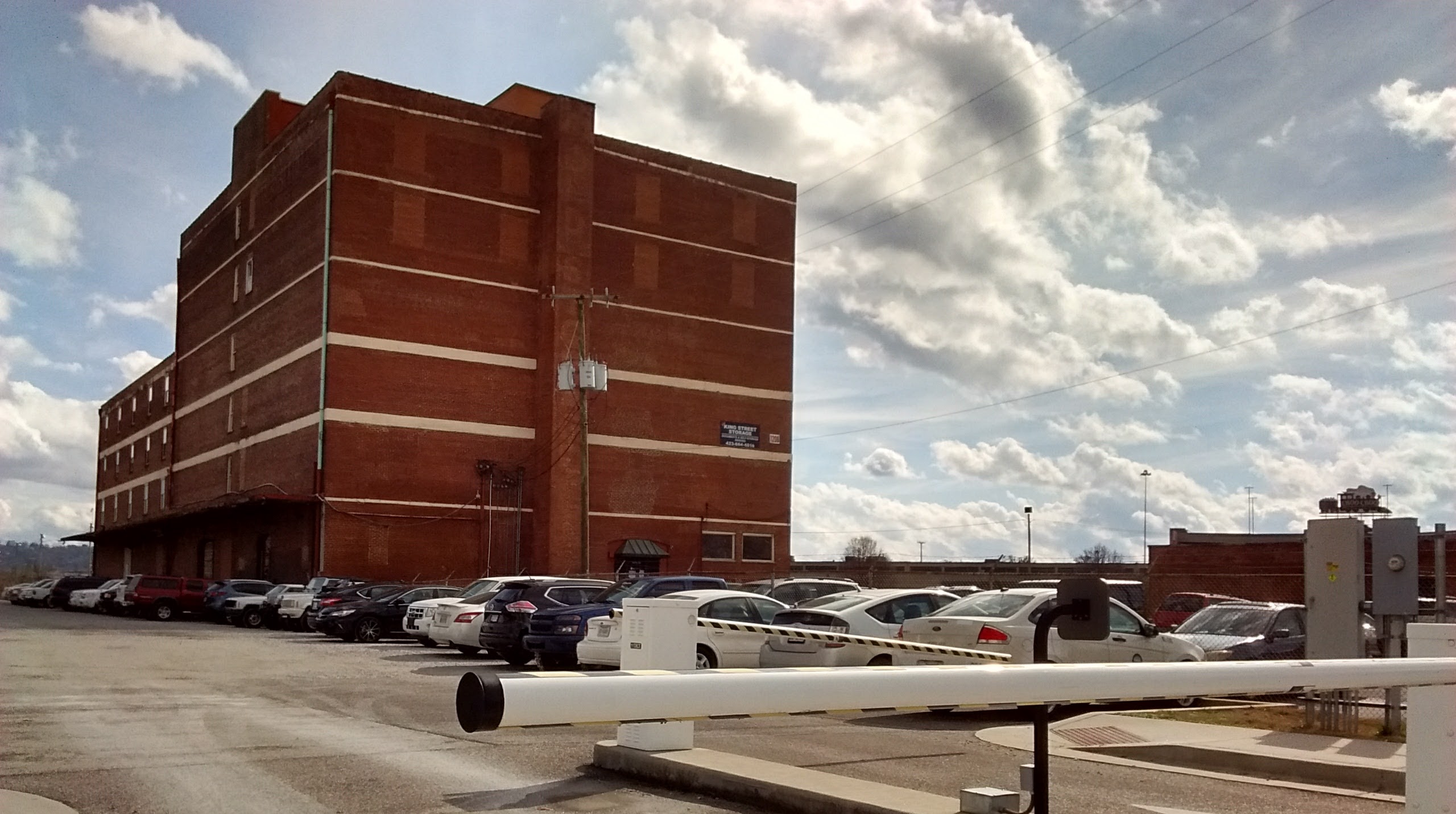 A gate controls access to a city-owned parking lot at 1200 King St.