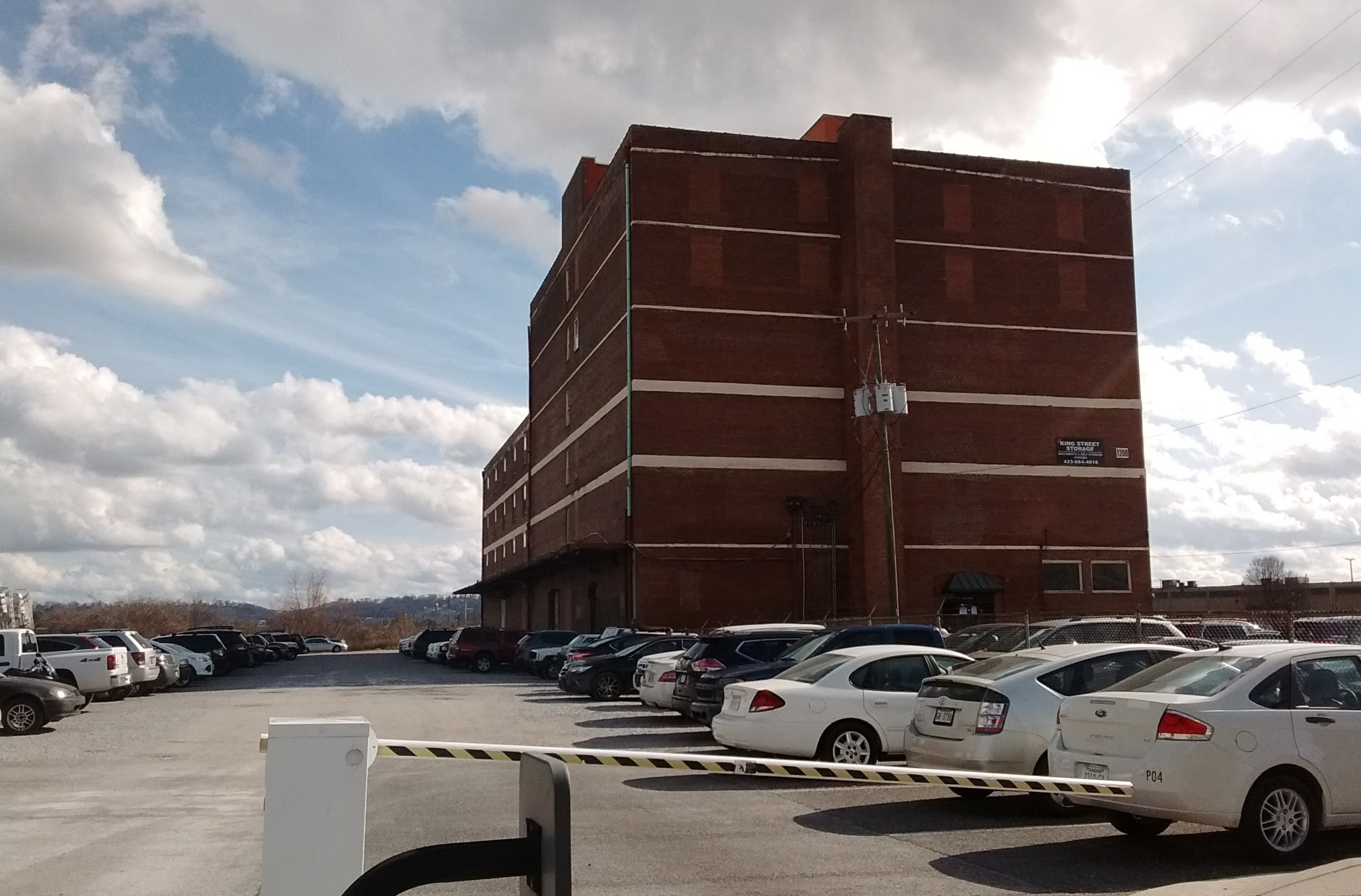A gate controls access to a city-owned parking lot at 1200 King St.