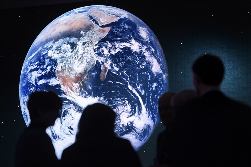
              Participants are silhouetted against a picture of the planet Earth on a giant screen during a panel session on the closing day of the 47th annual meeting of the World Economic Forum, WEF, in Davos, Switzerland, Friday, Jan. 20, 2017. (Laurent Gillieron/dpa via AP)
            