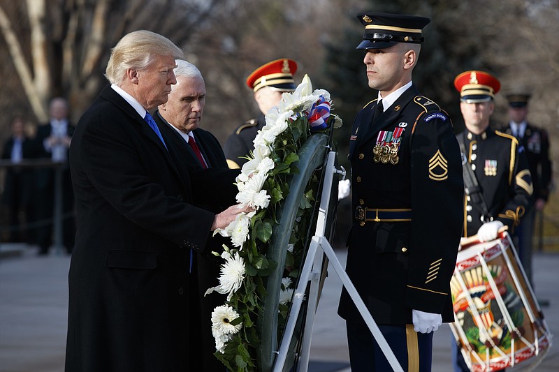 
              President-elect Donald Trump, accompanied by Vice President-elect Mike Pence places a wreath at the Tomb of the Unknowns, Thursday, Jan. 19, 2017, at Arlington National Cemetery in Arlington, Va., ahead of Friday's presidential inauguration. (AP Photo/Evan Vucci)
            