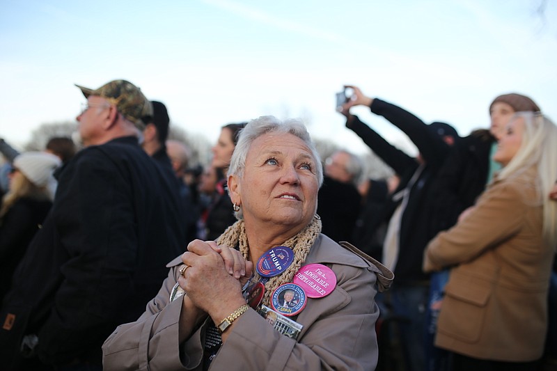 
              Amy Schramik of St. Petersburg, Fla. reacts to Donald Trump's appearance at a free concert on the grounds of the Lincoln Memorial and the Reflecting Pool on Thursday, January 19, 2017. Schramik was an assistant co-chair to the Hillsborough County Donald Trump Campaign. Formerly a Democrat, she converted to Republic in January 2015 so she could vote to nominate Trump. "I honestly think he's going to try to deliver what he promised. Deliver on his promises. Jobs. I'm not sure how much a president can do about jobs. The businesses are out there or they're not. He's got to come through on his promises," she said. (Charlie Kaijo/The Tampa Bay Times via AP)
            