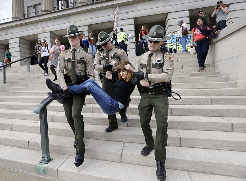 
              A protester is carried away from the Capitol, Friday, Jan. 20, 2017, in Nashville, Tenn. Protesters chained themselves to one another and to the Capitol building and emergency workers had to cut them free. The protest centered on the inauguration of President Donald Trump but included other social issues. (AP Photo/Mark Humphrey)
            