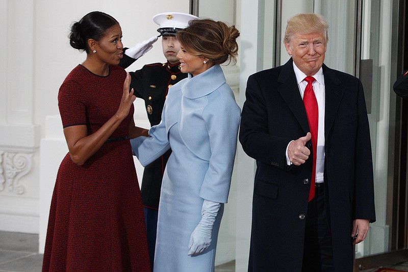 
              President-elect Donald Trump gives a thumbs-up as first lady Michelle Obama and Melania Trump talk at the White House in Washington, Friday, Jan. 20, 2017.  (AP Photo/Evan Vucci)
            