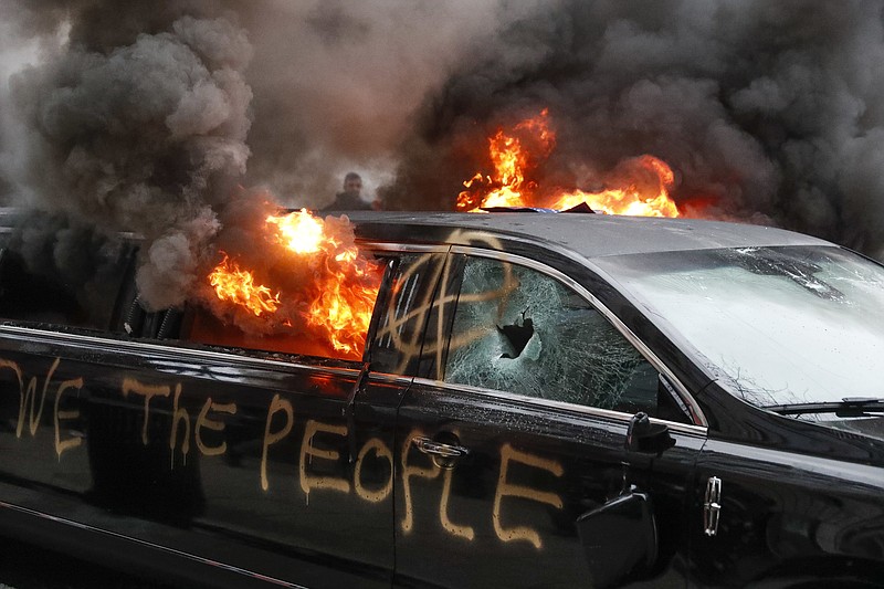 A parked limousine burns during a demonstration after the inauguration of President Donald Trump, Friday, Jan. 20, 2017, in Washington. Protesters registered their rage against the new president Friday in a chaotic confrontation with police who used pepper spray and stun grenades in a melee just blocks from Donald Trump's inaugural parade route. Scores were arrested for trashing property and attacking officers. (AP Photo/John Minchillo)