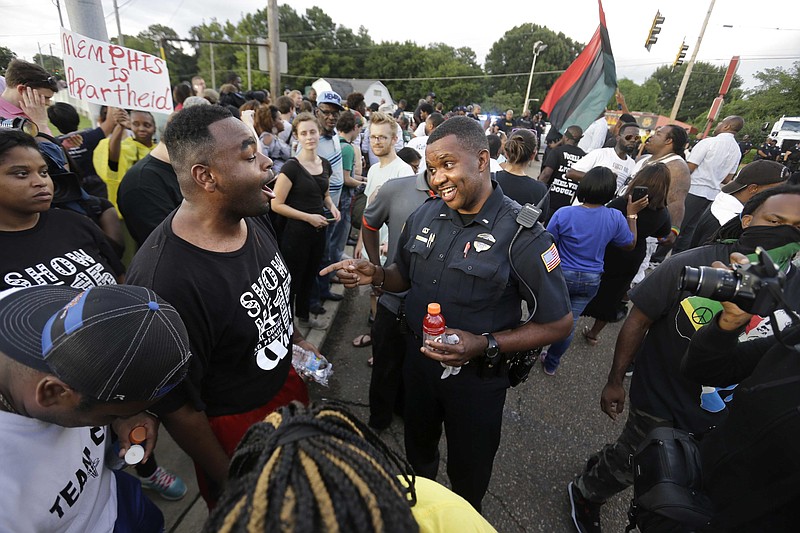 
              FILE - In this Aug. 15, 2016 file photo, Memphis police department Lieutenant A. Gardner, center right, talks with a protester, Antonio Blair, center left, during a protest at  Graceland's Elvis Candelight Vigil in Memphis, Tenn. Five people have filed a federal civil rights lawsuit against the city of Memphis and Elvis Presley's Graceland, saying they were discriminated against at a protest by a coalition associated with the Black Lives Matter movement during the annual vigil commemorating the singer's death.
Graceland owner, Elvis Presley Enterprises, and the city are named in the complaint filed Wednesday, Jan. 18, 2017 in federal court. (Nikki Boertman/The Commercial Appeal via AP)
            