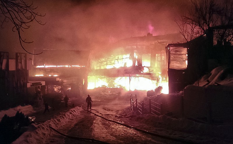 
              In this image provided by the Romania's General Inspectorate for Emergency Situations (ISU), a firefighter approaches the burning compound after a fire erupted in the early hours at the upmarket Bamboo nightclub, in Bucharest, Romania, Saturday, Jan 21, 2017. Fire engulfed a popular nightclub in the Romanian capital Saturday, sending more than 40 people to hospitals for treatment including one who was seriously injured. No deaths were reported.(ISU via AP)
            