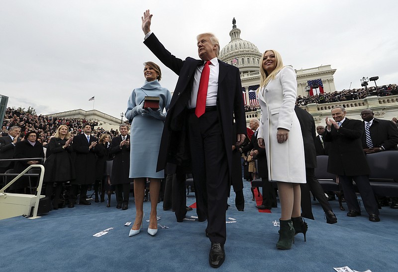 President Donald Trump waves after taking the oath of office as his wife Melania holds the Bible, and Tiffany Trump looks out to the crowd, Friday, Jan. 27, 2017 on Capitol Hill in Washington. (Jim Bourg/Pool Photo via AP)

