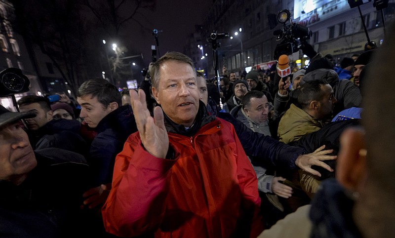 
              Romanian President Klaus Iohannis waves to the crowd in University Square during a protest against the government's proposal to pardon thousands of prisoners, in Bucharest, Romania, Sunday, Jan. 22, 2017.  Some thousands marched through the streets of the Romanian capital and other cities to protest against the pardon of prisoners which critics say could weaken the anti-corruption fight. (AP Photo/Andreea Alexandru)
            