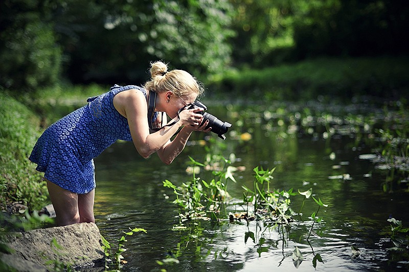 Beautiful girl taking photo at riverside