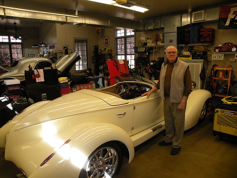 Charles Adams stands beside his 1936 Auburn Boattail Speedster in his workshop, which he designed and built in the style of a carriage house, outside of his home in Walden.