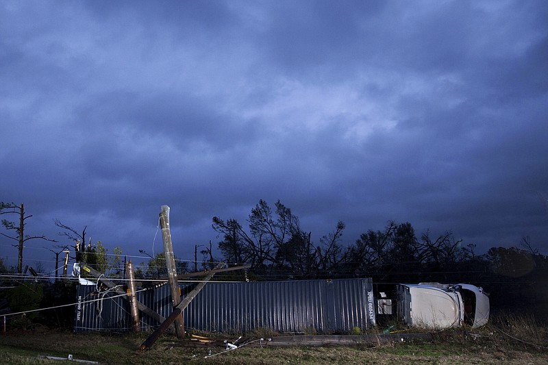 A tractor trailer truck that was damaged by an apparent tornado lays on its side, Monday, Jan. 23, 2017, in Albany, Ga. A vast storm system kicked up apparent tornadoes, shredded mobile homes and left other destruction scattered around the Southeast over the weekend. (AP Photo/Branden Camp)