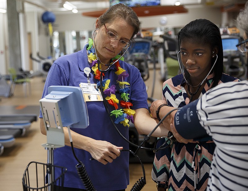 Cardiac rehab nurse Amy McCawley, left, shows intern Makalah Smith what a pulse sounds like while taking a patient's blood pressure in CHI Memorial Hospital's cardiac rehab facility on Thursday, July 14, 2016, in Chattanooga, Tenn. More than 40 businesses and organizations in Hamilton County have offered paid internships to high school students through the Step-Up Chattanooga program.