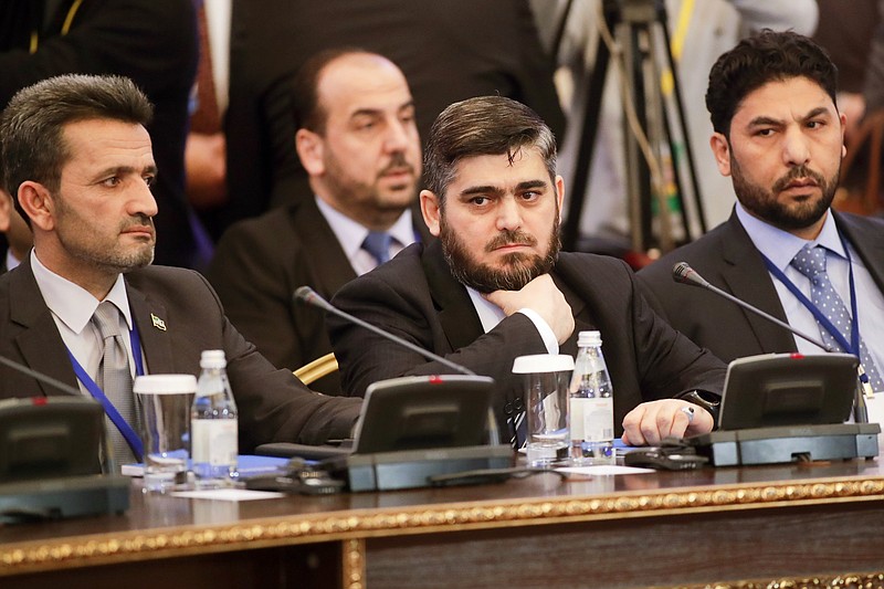 
              Mohammed Alloush, center, head of a Syrian opposition delegation, and other members attend talks on Syrian peace in Astana, Kazakhstan, Monday, Jan. 23, 2017. The talks are the latest attempt to forge a political settlement to end a war that has by most estimates killed more than 400,000 people since March 2011 and displaced more than half the country's population. (AP Photo/Sergei Grits)
            