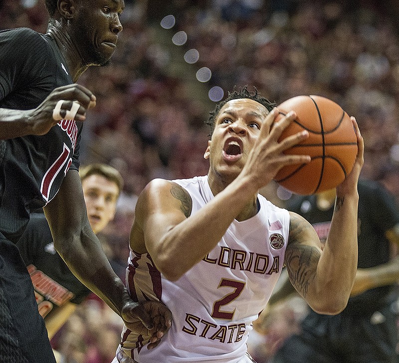 Florida State guard CJ Walker goes up for a basket against Louisville forward Mangok Mathiang in the second half of an NCAA college basketball game in Tallahassee, Fla., Saturday, Jan. 21, 2017. Florida State defeated Louisville 73-68. (AP Photo/Mark Wallheiser)