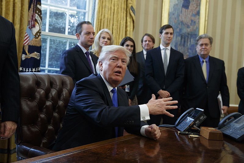 President Donald Trump talks with reporters n the Oval Office of the White House in Washington, Tuesday, Jan. 24, 2017, before signing an executive order on the Keystone XL pipeline. (AP Photo/Evan Vucci)