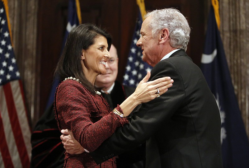 Former South Carolina Governor Nikki Haley, at left, congratulates current Governor Henry McMaster, in middle, after he was sworn in by S.C. Chief Justice Don Beatty during a ceremonial swearing in at the Statehouse Tuesday Jan. 24, 2017, in Columbia, S.C. Haley resigned as governor after she became ambassador to the United Nations. (AP Photo/Mic Smith)