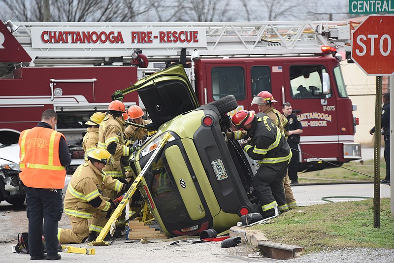 Chattanooga Fire Department personnel work to extract two occupants from a Kia vehicle on its side Wednesday afternoon in the 1700 block of Central Avenue.