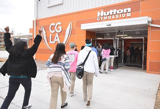 Chattanooga Girls Leadership Academy 8th grader Jakavia Brydie, left, raises her hands with joy as she and fellow students walk into the newly renovated Hutton Gymnasium for Wednesday's celebration of the opening in Highland Park. The gym will be the home of the Mustang's led by coach Justin Booker.