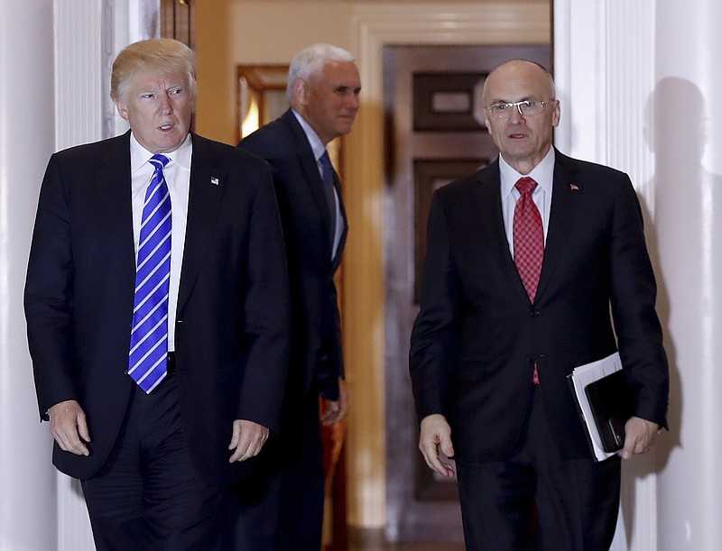 
              FILE - In this Nov. 19, 2016 file photo, President-elect Donald Trump walks Labor Secretary-designate Andy Puzder from Trump National Golf Club Bedminster clubhouse in Bedminster, N.J. Puzder was CEO of a fast food empire that is outsourcing jobs on his watch, a stark contrast with his boss' threats and tweeted slaps at companies that outsource jobs.  (AP Photo/Carolyn Kaster, File)
            