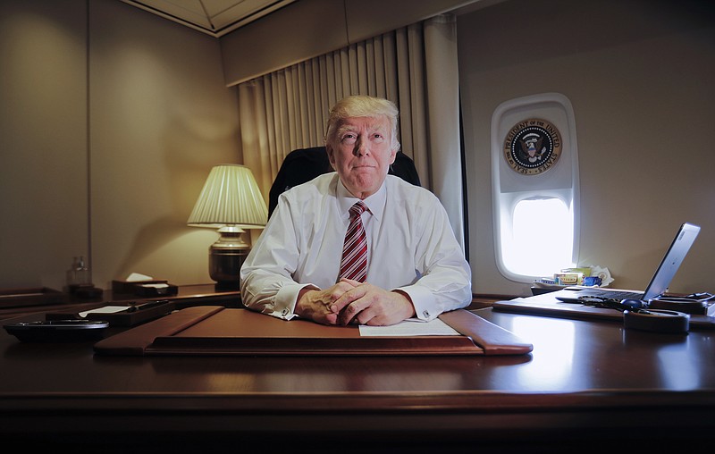 
              President Donald Trump sits at his desk on Air Force One upon his arrival at Andrews Air Force Base, Md., Thursday, Jan. 26, 2017. (AP Photo/Pablo Martinez Monsivais)
            