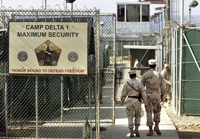 
              FILE - In this June 27, 2006 file photo, reviewed by a US Department of Defense official, US military guards walk within Camp Delta military-run prison, at the Guantanamo Bay US Naval Base, Cuba. A draft executive order shows President Donald Trump asking for a review of America’s methods for interrogation terror suspects and whether the U.S. should reopen CIA-run “black site” prisons outside the U.S.  (AP Photo/Brennan Linsley, file)
            