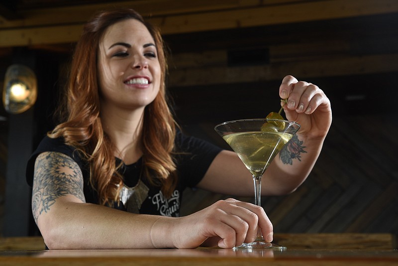 Sara Keith holds a classic martini she mixed at the Flying Squirrel bar.