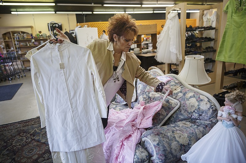 2nd Chance Thrift manager Debbie Citrullo picks up vintage dresses at the Humane Educational Society's resale store. About 30 dresses from the '50s and '60s will be up for sale during an auction in March.