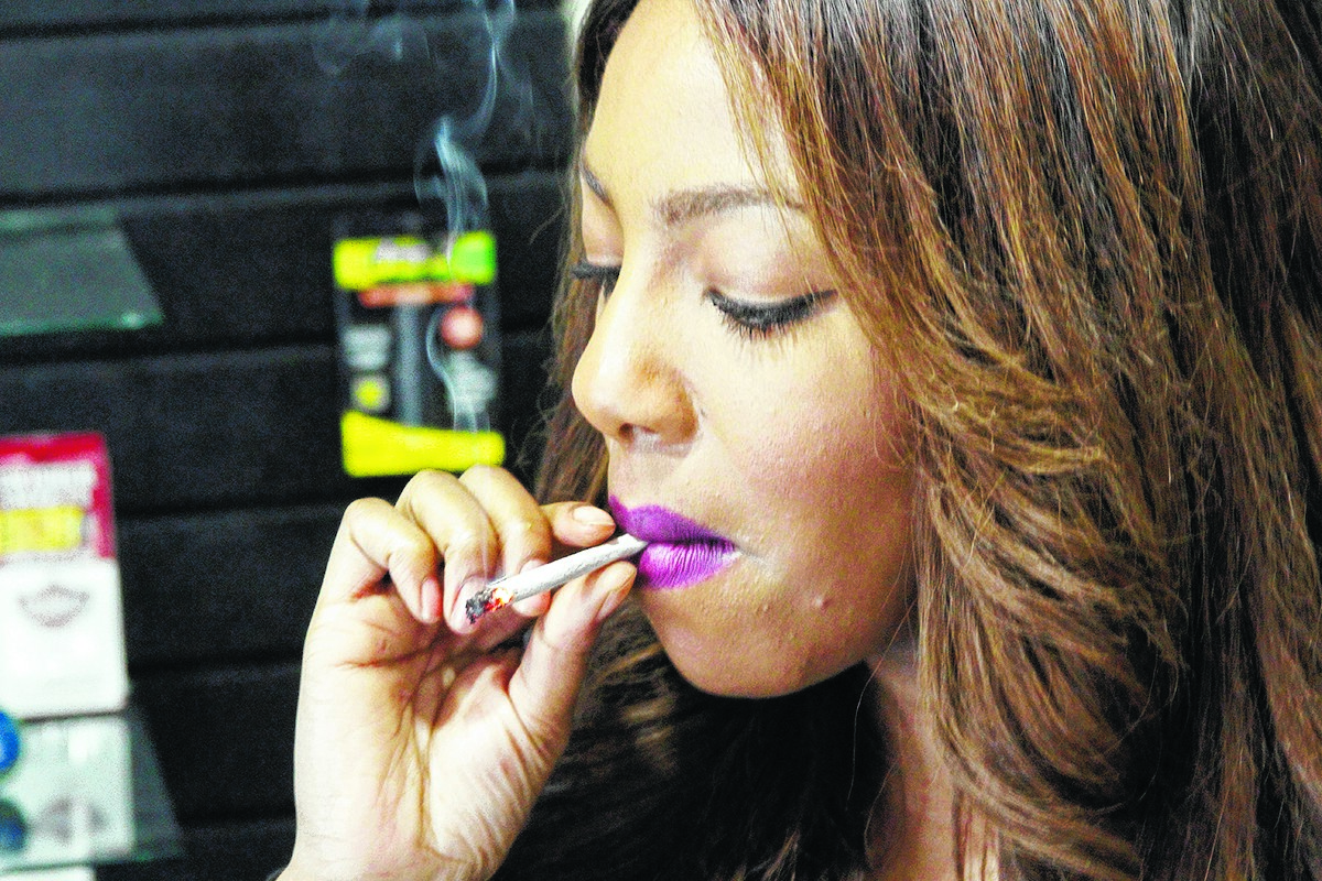 In this Feb. 20, 2015, photo, Alaska Cannabis Club CEO Charlo Greene smokes a joint at the medical marijuana dispensary in Anchorage, Alaska. On Tuesday, Feb. 24, 2015, Alaska will become the third state in the nation to legalize marijuana. (AP Photo/Mark Thiessen)