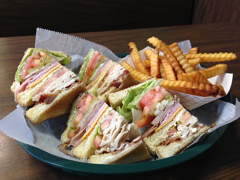 The Snack Shack's club sandwich, here with a side of golden crinkle fries, is a formidable collection of thick wedges of ham, turkey, roast beef, bacon and American cheese lubricated with mayonnaise and topped with lettuce, tomato, pickle and onion and nestled between three layers of Texas toast.