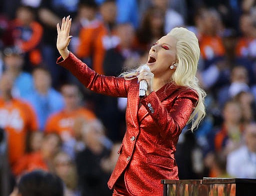 FILE - In this Feb. 7, 2016, file photo, Lady Gaga sings the national anthem before the NFL Super Bowl 50 football game in Santa Clara, Calif. Lady Gaga is reportedly planning an (unconfirmed) stunt during Super Bowl LI by performing from the roof of the stadium during the big game. Advertisers are also ramping up their marketing stunts to try to stand out from the crowd during the biggest live TV event of the year, when the Atlanta Falcons will take on the New England Patriots, in the Super Bowl. (AP Photo/Jae C. Hong, File)