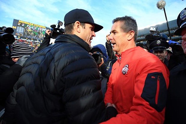 Michigan football coach Jim Harbaugh and Ohio State counterpart Urban Meyer, shown here after Meyer's Buckeyes won in 2015, are racking up top-notch recruiting classes on an annual basis.