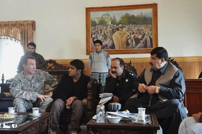 In this 2010 photo provided by U.S. Army Capt. Matthew Ball shows his interpreter Qismat Amin, second seated from left, in Jalalabad, the capital of Nangarhar province of Afghanistan. Amin, who has been living in hiding after getting threats from Taliban and Islamic state fighters, got his visa Sunday, Jan. 29, 2017, after nearly four years of interviews. Ball bought him a $1,000 plane ticket to San Francisco and plans to meet him at the airport with an attorney. Ball said he has bought a plane ticket for his Afghan translator in case that country is added to the list of banned nations. (U.S. Army Capt. Matthew Ball via AP)